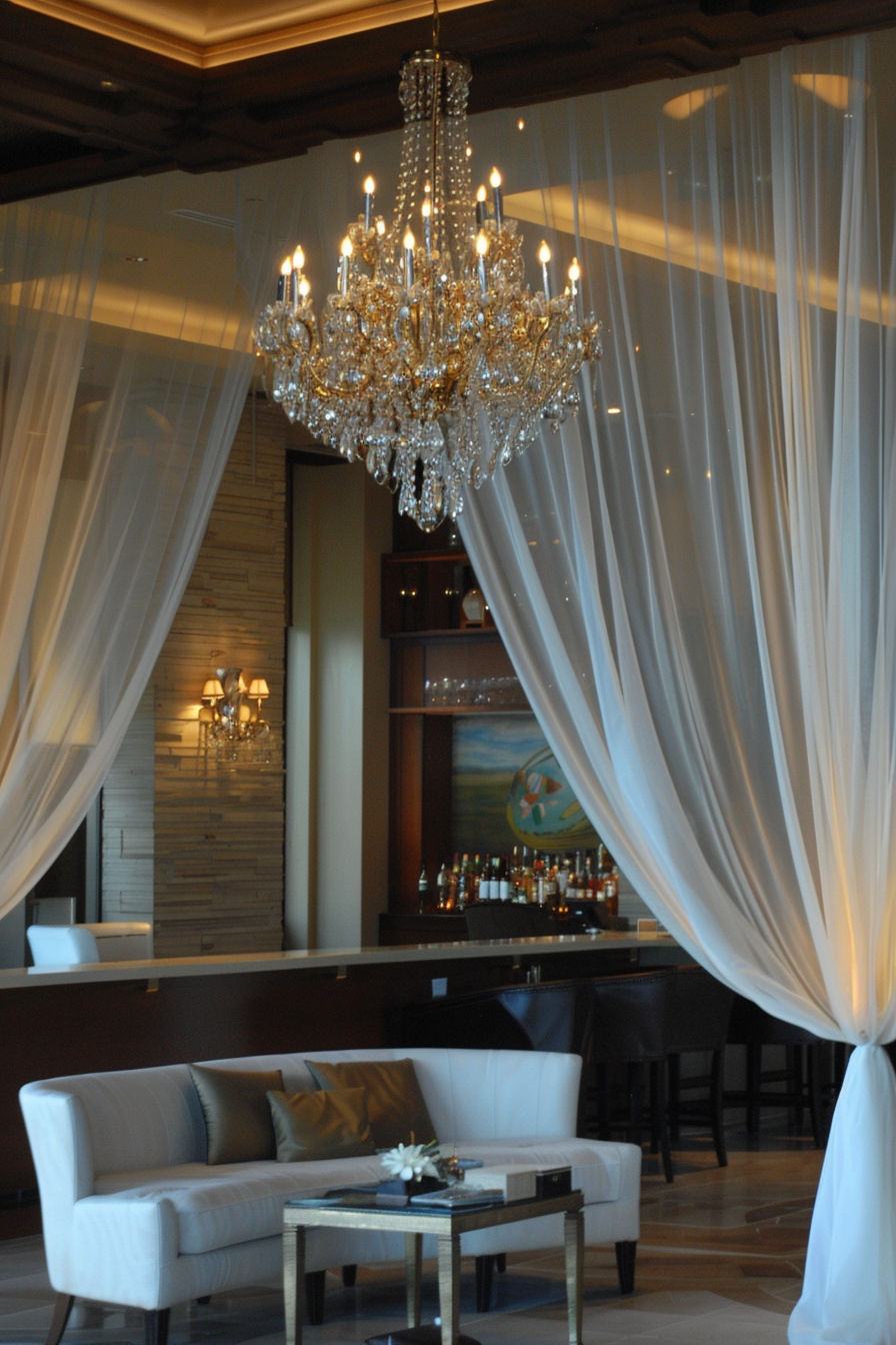 Reception area. Gold threaded white draped fabrics over crystal chandelier.